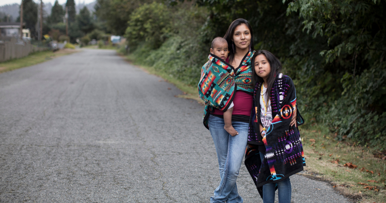 A Native mother poses for a photo with her two children. 