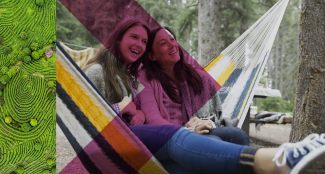 two women in a hammock, smiling