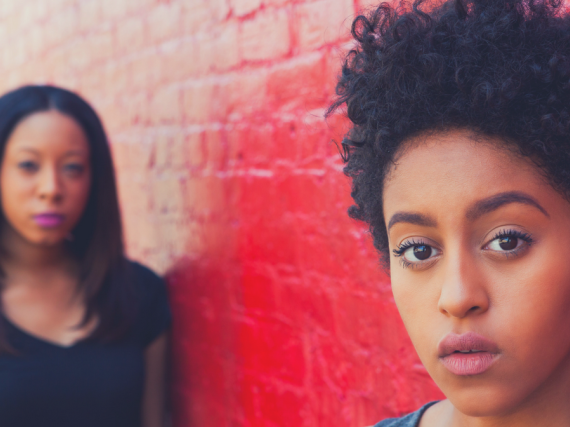 Two black women look into the camera