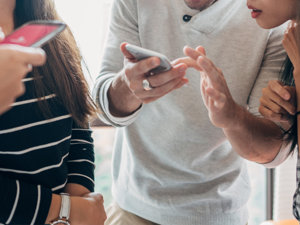 young people looking at cell phones