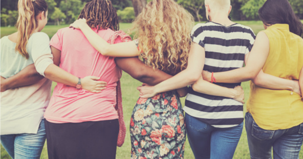 An image of 5 friends with their arms around each others backs